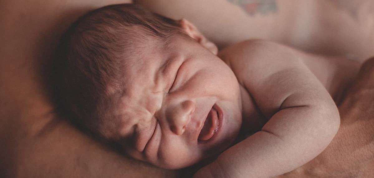 baby crying in hands